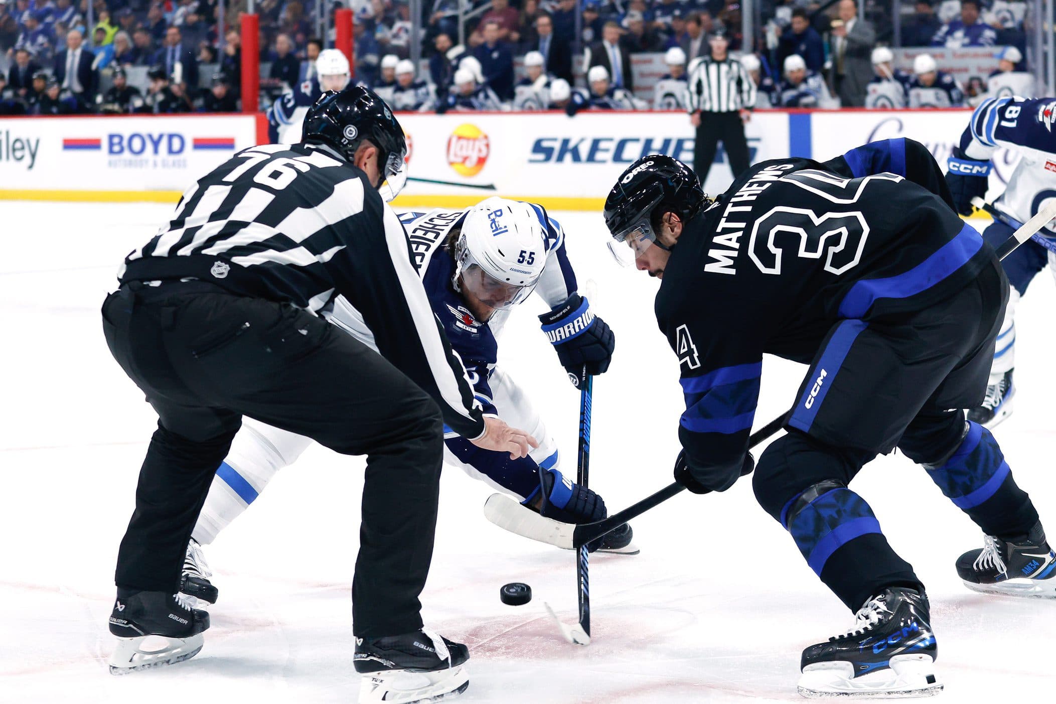 Winnipeg Jets forward Mark Scheifele (55) faces off against Toronto Maple Leafs forward Auston Matthews (34) during the first period at Canada Life Centre.