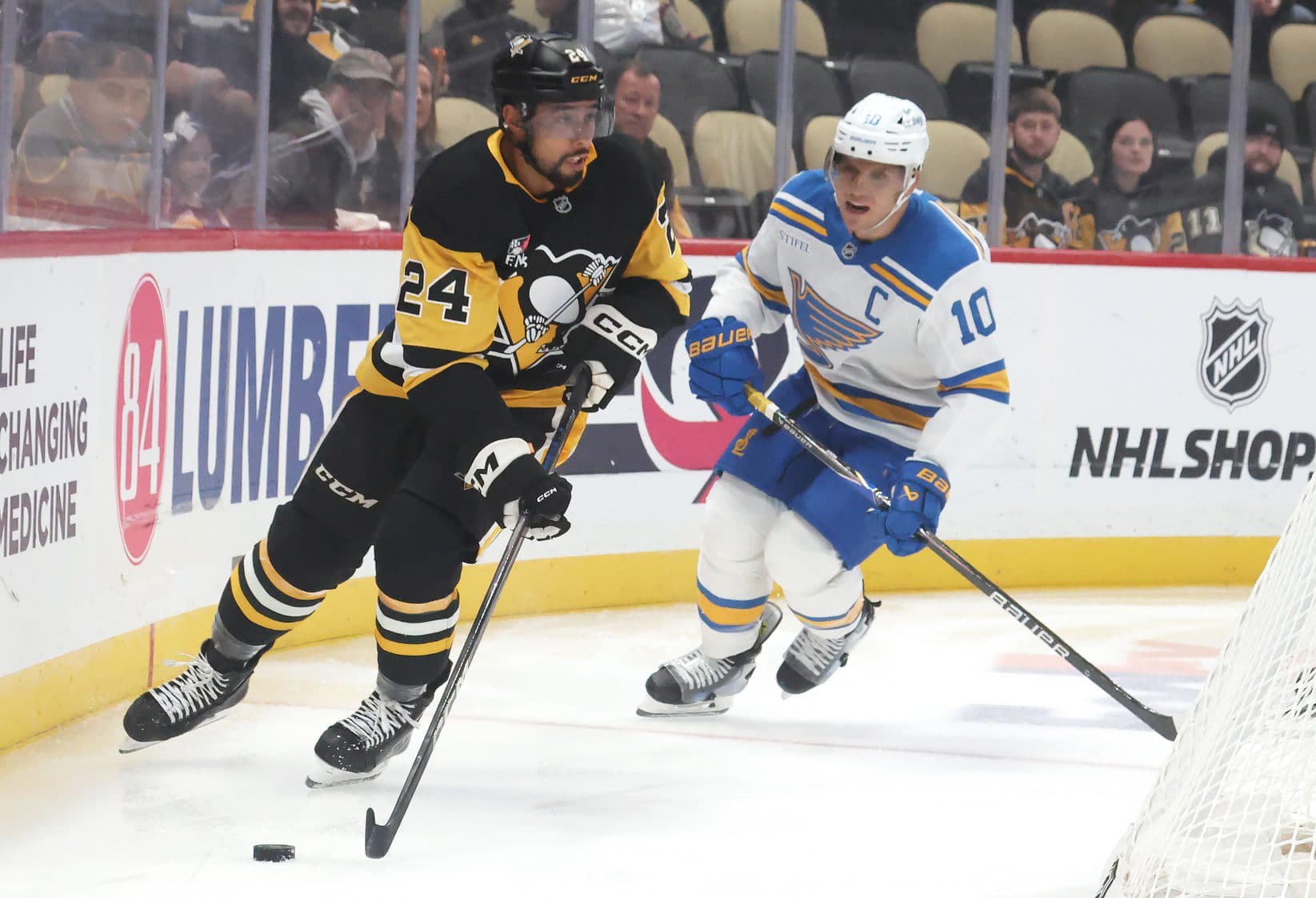 Pittsburgh Penguins defenseman Mathew Dumba (24) moves the puck against St. Louis Blues center Brayden Schenn (10) during the first period at PPG Paints Arena.
