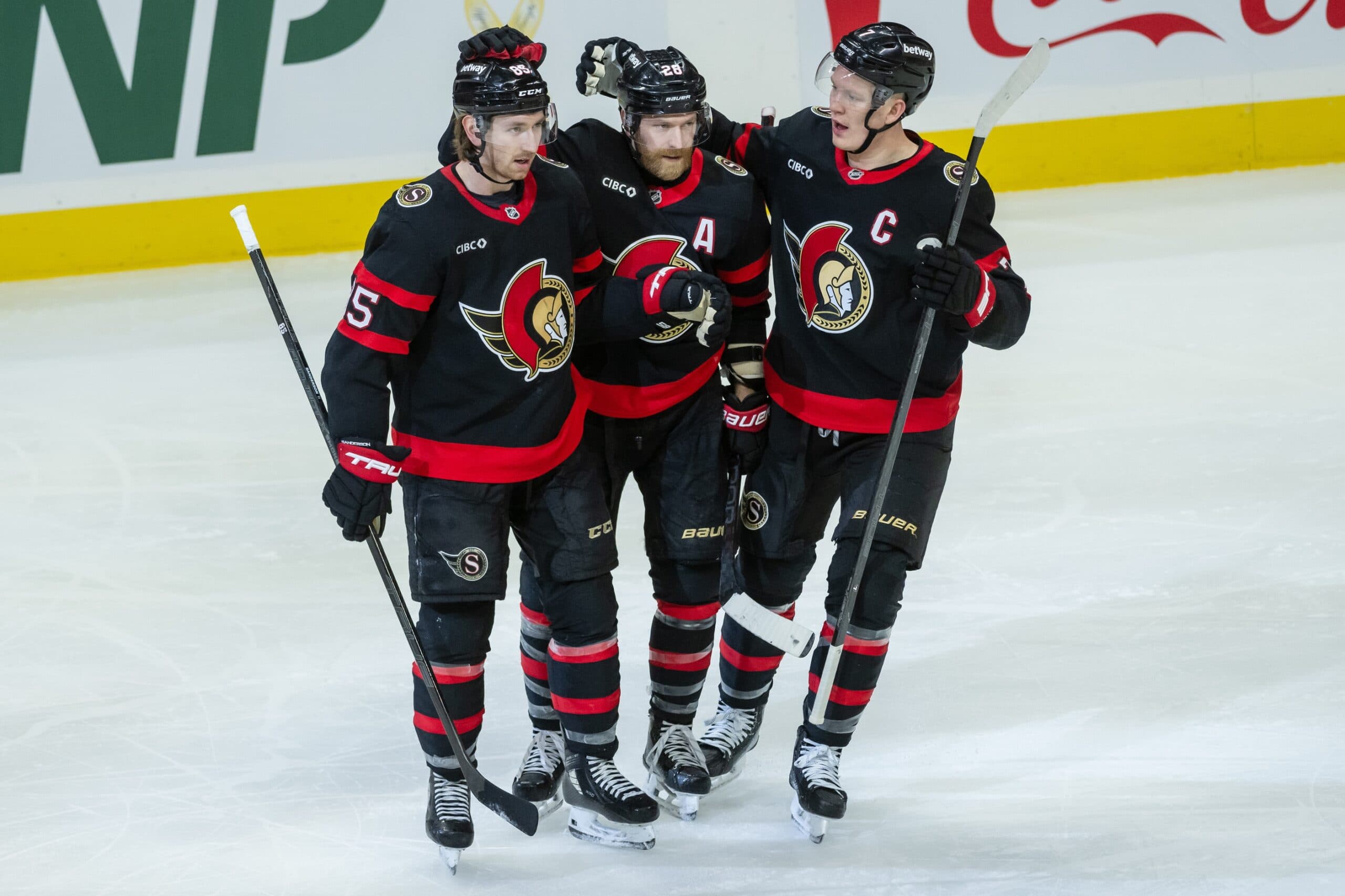 Ottawa Senators defenseman Jake Sanderson (85) is celebrated by right wing Claude Giroux (28) and left wing Brady Tkachuk (7) for his goal scored in the third period against the Washington Capitals at the Canadian Tire Centre